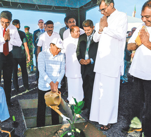 President Maithripala Sirisena watering a plant at the Karadiyana waste management project inauguration.