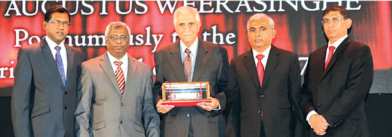 Sohli Captain accepts the award on behalf of the late L.A. Weerasinghe from incumbent CA Sri Lanka President Lasantha Wickremasinghe. Also present are Vice President Jagath Perera, Chairman of the Hall of Fame Committee Mohan Abeynaike and CEO Aruna Alwis