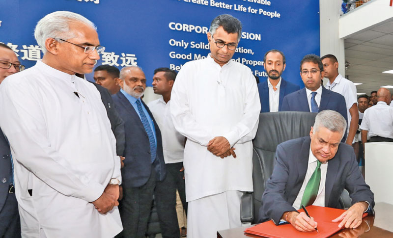 Prime Minister Ranil Wickremesinghe signing the visitor’s book at the Colombo Port City premises. He made an inspection tour at the project site on Tuesday accompanied with Western Development and Megapolis Minister Patali Champika Ranawaka, Finance State Minister Eran Wickremaratne and Policy Planning and Economic Development Deputy Minister Dr Harsha de Silva. Picture by Hirantha Gunathilaka