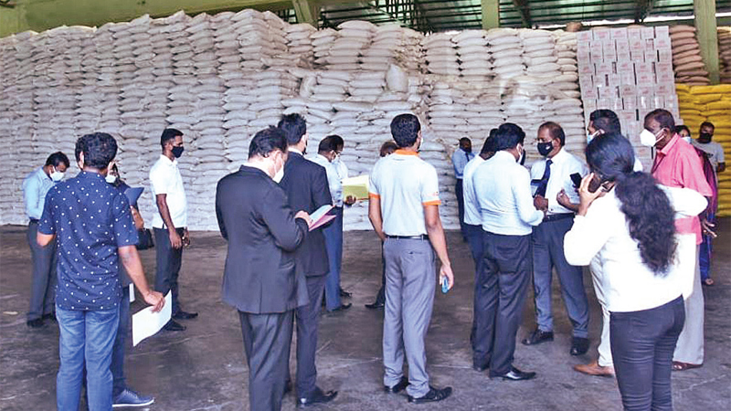 Consumer Affairs Authority officials inspecting sugar stocks hoarded by traders in Kandy yesterday. Picture by Chinthaka Kumarasinghe