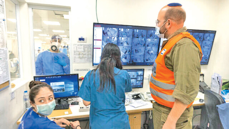 Shaare Zedek staff and an IDF Home Front Command soldier are seen in a monitoring room in the Coronavirus ward of a hospital in Jerusalem.