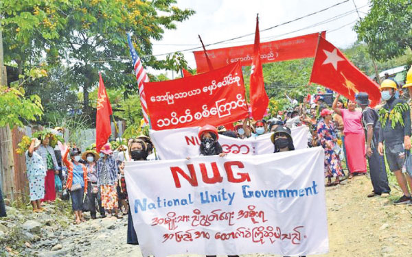 This handout photo from Kachinwaves shows protesters marching with banners supporting the opposition National Unity Government (NUG) during a demonstration against the military coup in Hpakant in Myanmar’s Kachin state.