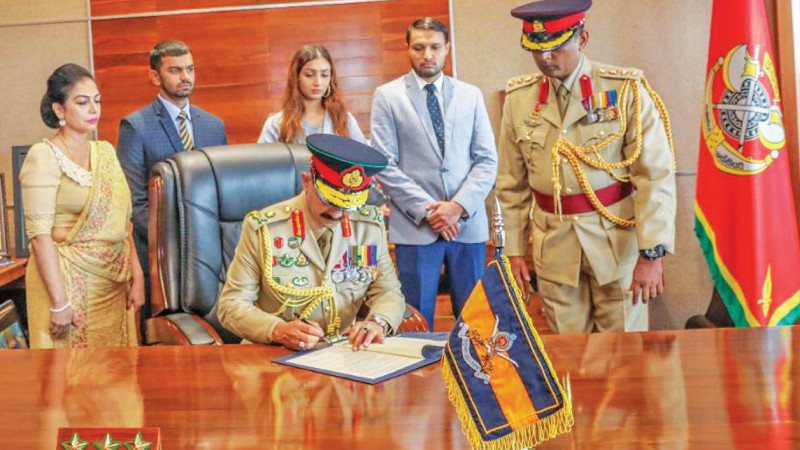 Army Commander Lt. Gen. Vikum Liyanage, flanked by his wife Mrs. Janaki Liyanage and family members signing a formal document to assume duties.