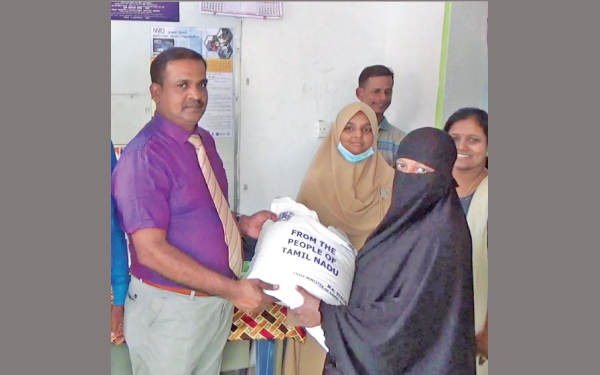 Kattankudy Divisional Secretary U. Uthayasrithar hands over a relief pack to a beneficiary in Kattankudy. Picture by Sivam Packiyanathan