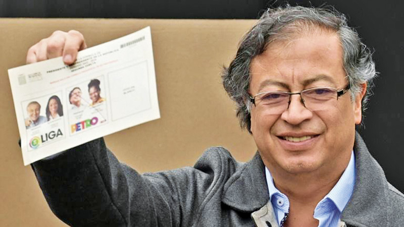 Colombia's first ever leftist President-elect Gustavo Petro shows his polling card after voting in Bogota.