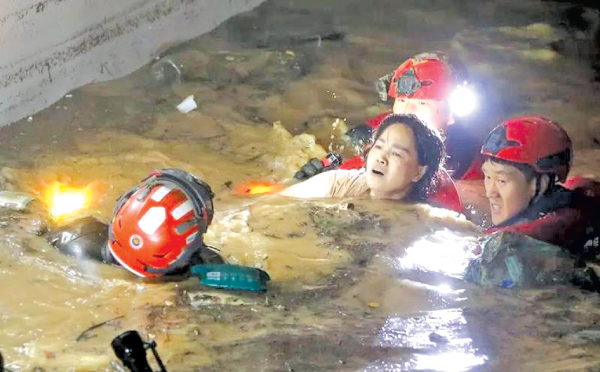 A woman trapped by the raging floodwaters being rescued in South Korea.