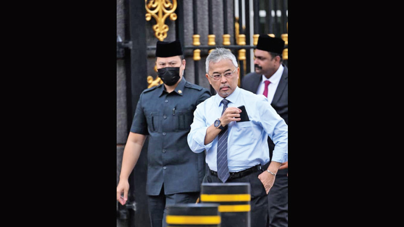 Malaysia’s King Sultan Abdullah Sultan Ahmad Shah (second from right), walking to meet members of the media outside the National Palace in Kuala Lumpur on Monday.