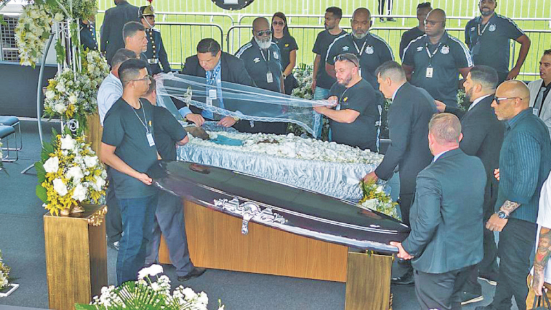 Funeral workers uncover the coffin of the late Brazilian soccer great Pele 