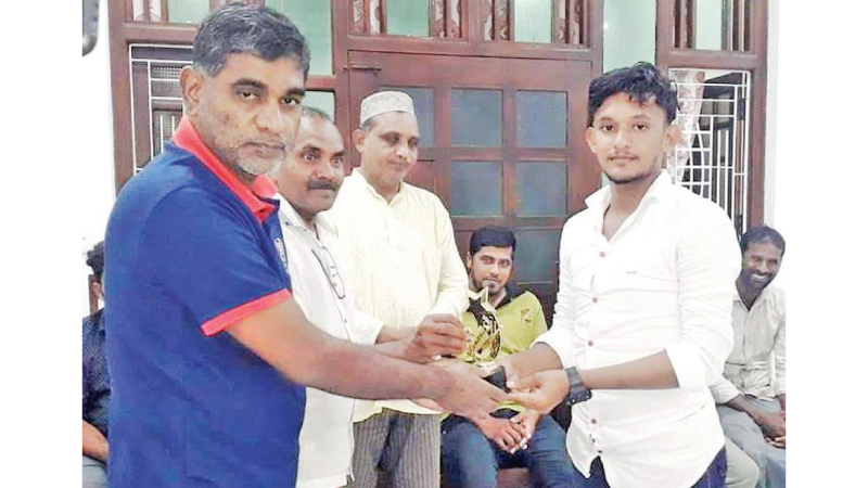 Addalaichenai Sport Officer M.H.M. Aswath (on left) handing over a memento to a medalist of the sports festival