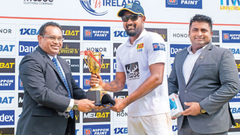 Prabath Jayasuriya who took a match bag of 7 wickets became the fastest-ever spinner to 50 Test wickets is receiving the Man of the Match award from Sri Lanka Cricket Head of Administration Aruna de Silva (left)  at the presentation ceremony held at Galle yesterday. (Pic courtesy SLC) 