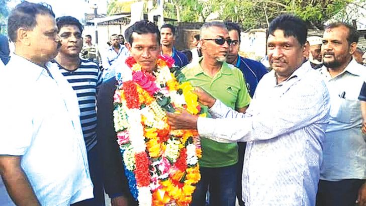 Champion athlete Siyad Mohamed being welcomed at his home town by the Principal of Km/Km/Al-Ashraq National School, Nintavur S.M.M.Jabeer while the Chief Inspector of Police M.L.Rafeek looks on. Picture by A. B. Abdul Gafoor, Ampara District Group Corr. 