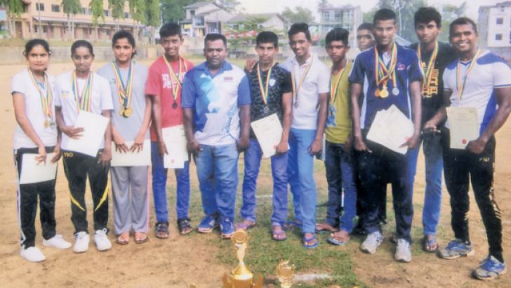 The member of Shiva Shakthi Sports Club, Poruwadanda, are seen hear with their certificates and cups, with their coach B Sudharshan (in the middle) who made a tremendous effort to win the Overall Sports Championship. (Pic Kalutara Central Special Correspondent H L Sunil Shantha.)   