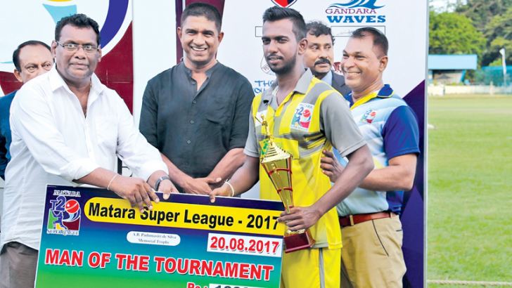 Man of the Tournament Harsha Rajapaksha receives the trophy and cash award from Gemunu de Silva (ROCA) and Pramodya Wickremasinghe