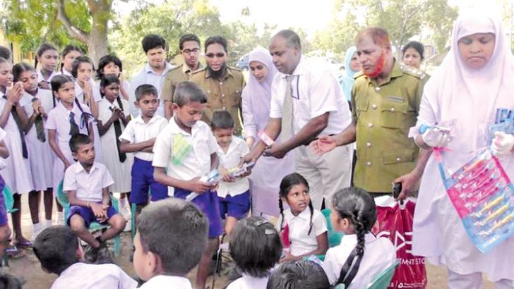 Dr. Latheef distributes toothpaste and toothbrushes.