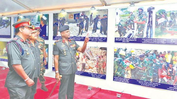Army Commander Lt.Gen. Mahesh Senanayake viewing a collection of photos taken during projects being carried out by the Army for promotion of reconciliation and nation building which were also on display at the exhibition. 