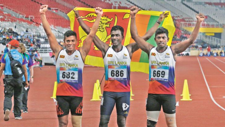 Amila Prassana , Indika Ginadasa and Keerthi Bandara posing with the Sri Lanka flag after winning the 100 metres T42, 63 event.   Picture by Prince Gunasekara   