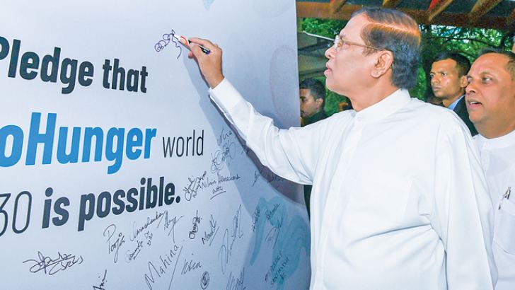 President Maithripala Sirisena signs the pledge to work for zero hunger, at World Food Day celebrations in Colombo, on Tuesday. 