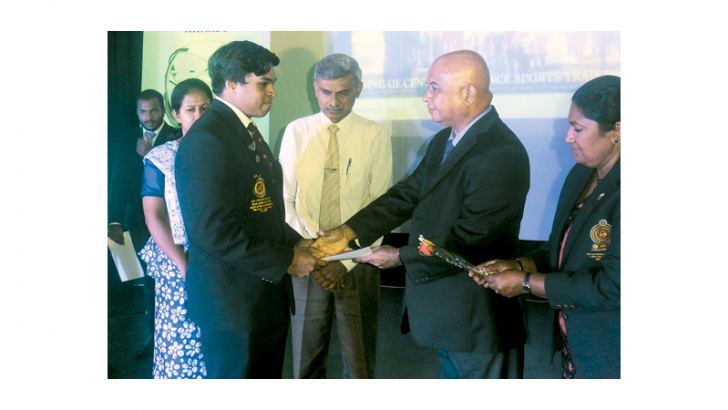 B. Wijewickrema who won a silver medal for weightlifting at the National Games receiving a cash award from the Chief Secretary (CP) Gamini Rajaratne. 
