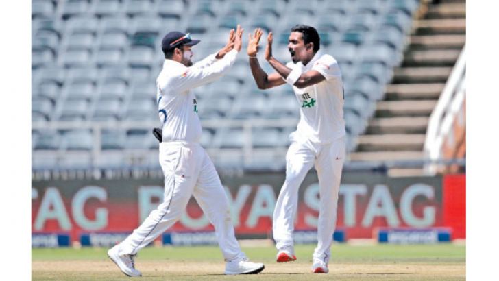 Sri Lanka’s Vishwa Fernando (R) celebrates with Sri Lanka’s captain Dimuth Karunaratne (L) after the dismissal of South Africa’s Lutho Sipamla during the second day of the second Test cricket match at the Wanderers stadium in Johannesburg on January 4, 2021. 