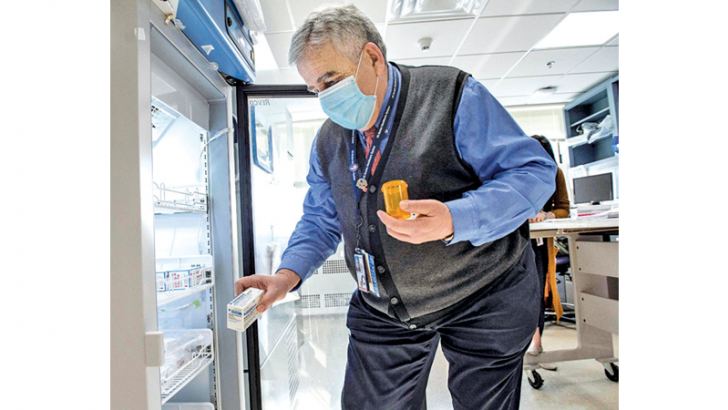 Pharmacist Antoun Houranieh unlocks a refrigerator and takes out a box of the Johnson & Johnson COVID -19 Janssen Vaccine to be used for the day's at home vaccinations at the US Department of Veterans Affairs' VA Boston Healthcare System's Jamaica Plain Medical Center in Boston, Massachusetts on Thursday. - AFP