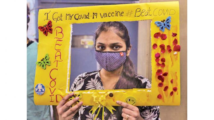 An Indian teenager holds a notice after receiving a Covaxin inoculation in Hyderabad.