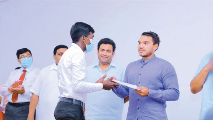 Minister Namal Rajapaksa awarding a certificate to a youth who completed training in Construction Equipment Operation.  Picture by Nimal Wijesinghe