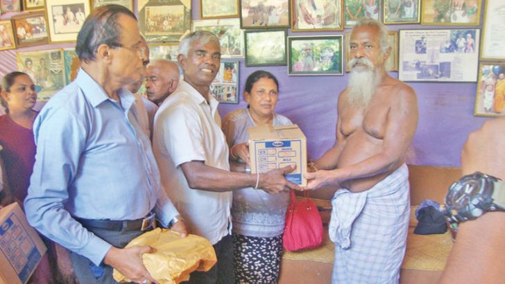 Members of the Gokarella Elders’ Society hand over gift parcels to Veddha Chief Wanaspathi Uruwarige Wannilaaththo, in Dambana recently.