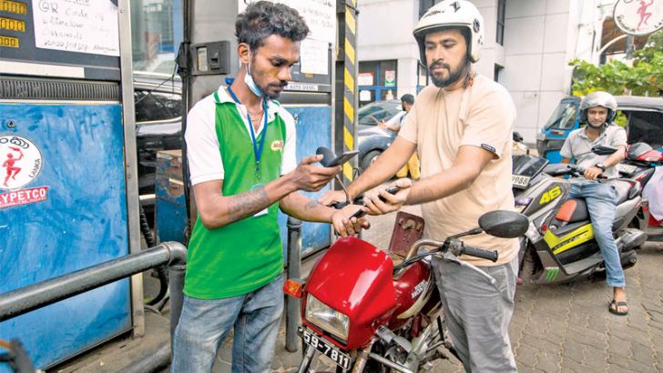 A worker scans a QR code  before pumping fuel.  Picture by Sulochana Gamage
