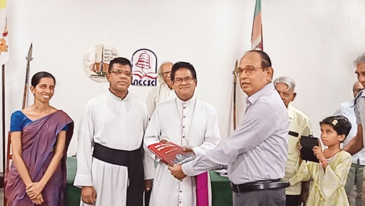 Newly appointed President of National Catholic Writers’ Organisation  Godfrey Cooray is presenting his book to Axillary Bishop of Colombo,Maxwell Silva. Picture by Joesph Pius