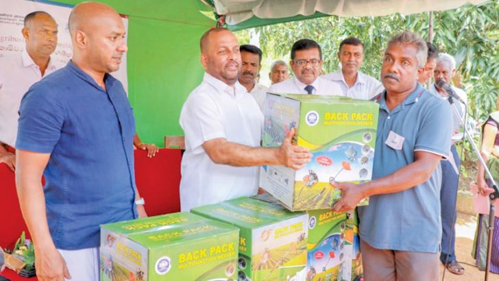 Agriculture Minister Mahinda Amaraweera distributing agriculture equipment to farmers. Anuradhapura District Parliamentarian Duminda Dissanyake is also present. 