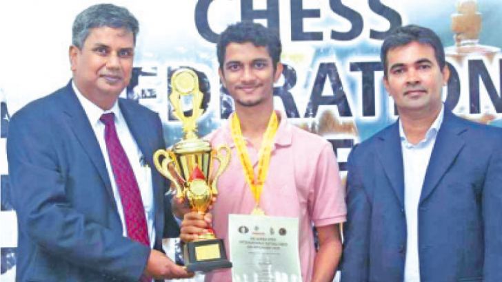 Deepthi Hewageegana, Deputy President of the Chess Federation of Sri Lanka hands over the Trophy to Thejaka Dissanayake while Erosh Jayasinghe, Treasurer of the Chess Federation of Sri Lanka looks on. 